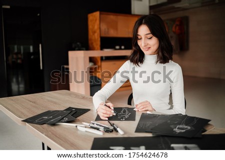 Woman designer drawing fashion sketches for her future collection