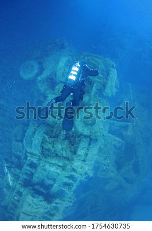 A scuba diver floats over the wreckage of a truck that was part of the cargo of the sunken ship wreck Zenobia, Cyprus