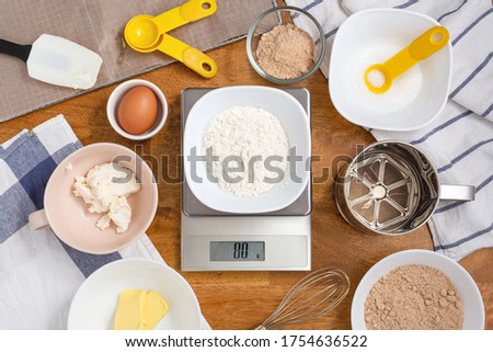 Flour on digital scale with cookie ingredients for baking on wooden table Royalty-Free Stock Photo #1754636522