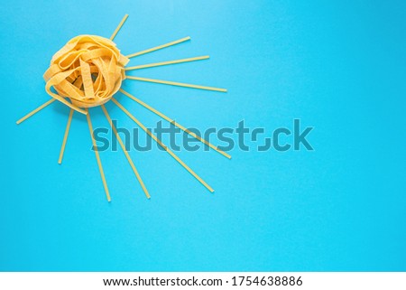 the sun of pasta, spaghetti and fettuccine on a blue background, layout for the menu, a bright picture of Italian traditional cuisine