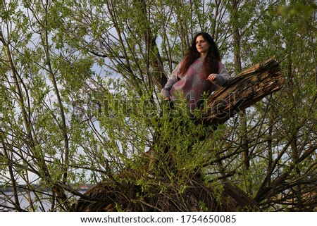 Beautiful photo of a young woman with an expressive look.A brunette with long loose hair in a rough loose sweater in the wild at the end of the day.Russia