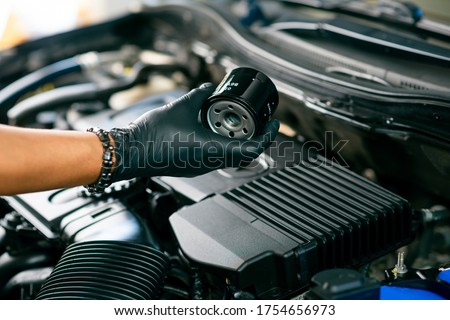 Technician change car oil filter, automotive spare part. Car maintenance concept. Royalty-Free Stock Photo #1754656973