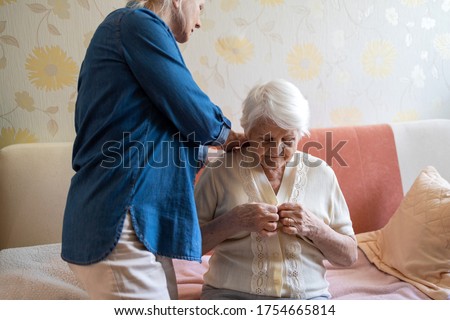 Woman helping senior woman dress in her bedroom
 Royalty-Free Stock Photo #1754665814