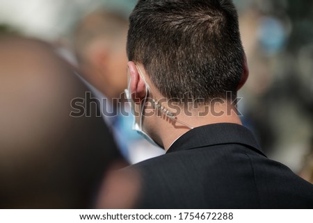 Protection and Guard Service (SPP, Romanian version of the US Secret Service) officer, wearing a mask during the Covid-19 outbreak, during a public visit of a dignitary. Royalty-Free Stock Photo #1754672288