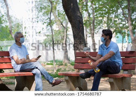 Senior man sitting and enjoy nature with mask on face.
