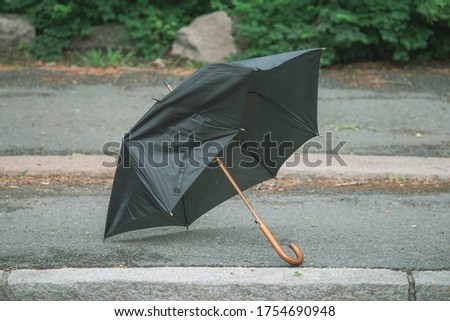 Broken umbrella thrown away and laying on the street. Royalty-Free Stock Photo #1754690948