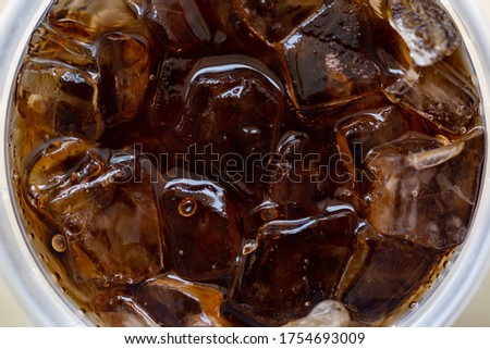 Top view and close-up cola with ice in plastic glass.