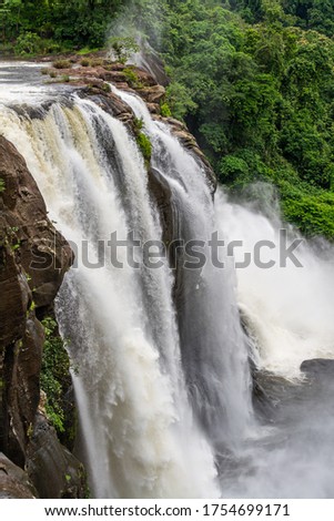 Beautiful nature view during Mansoon time with full filled water fall and green forest from the famous tourist place in Kerala, India called Athirappalli, Vaazhachaal