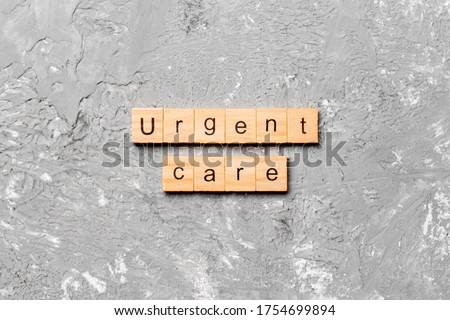 Urgent care word written on wood block. Urgent care text on cement table for your desing, concept.