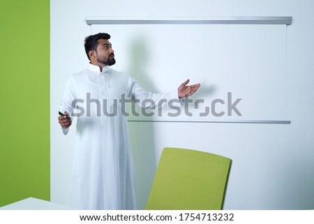 Saudi Arab Man giving presentation in conference room in office in meeting