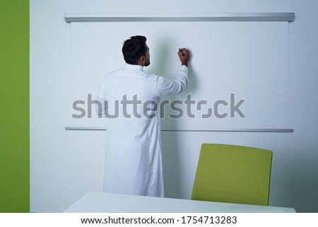Saudi Arab Man writing on white board in conference room