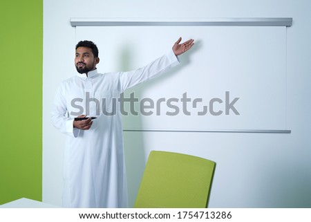 Saudi Arab Man giving presentation in conference room in office