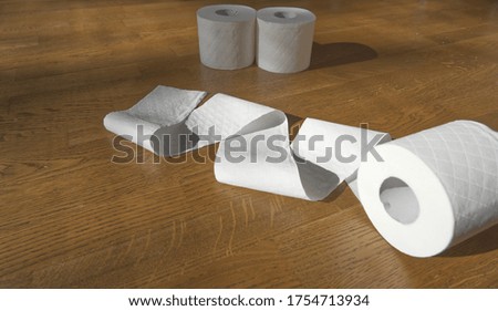 Toilet paper rolls on wooden floor at home, paper crisis, pandemic concept