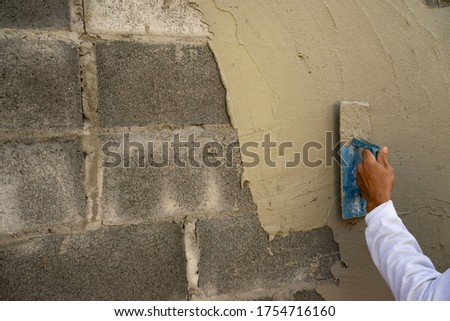 Plaster is plastering the cement mortar for the job.