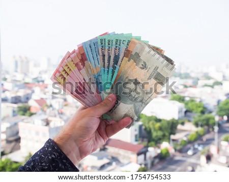 Indonesian money in the hands of a man.