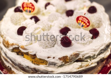 biscuit cake with whipped cream candles and cherries