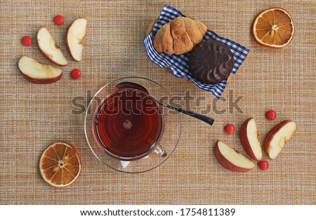 Croissants, chocolates and tea on brown background. Sweet food concept. Top view food.