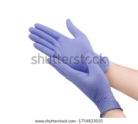 Two purple surgical medical gloves isolated on white background with hands. Rubber glove manufacturing, human hand is wearing a latex glove. Doctor or nurse putting on nitrile protective gloves Royalty-Free Stock Photo #1754823035