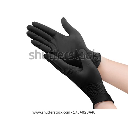 Two black surgical medical gloves isolated on white background with hands. Rubber glove manufacturing, human hand is wearing a latex glove. Doctor or nurse putting on nitrile protective gloves Royalty-Free Stock Photo #1754823440