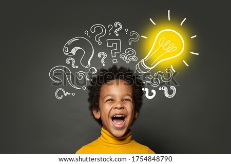 Laughing child boy student with lightbulb and question marks. Brainstorming and idea concept Royalty-Free Stock Photo #1754848790