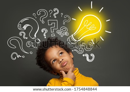 Thinking child boy on black background with light bulb and question marks. Brainstorming and idea concept Royalty-Free Stock Photo #1754848844