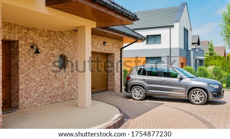 Residential house with silver suv car parked on driveway in front. Family house - perfect neighborhood concept Royalty-Free Stock Photo #1754877230