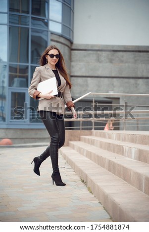 Beautiful young girl in a business suit on a background of business center. Business theme