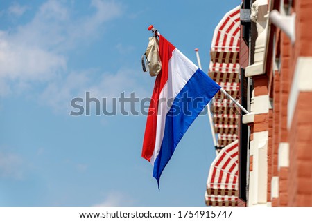 Official Netherlands flag with a school bag hanging out side the house in Amsterdam, A tradition way in Holland when a student celebrate their graduates or Geslaagd in Dutch word.
