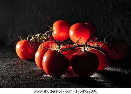 A closeup shot of fresh cherry tomatoes on a black background