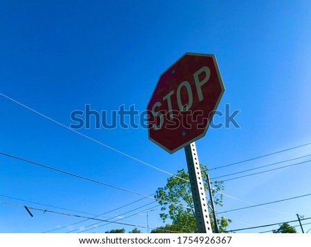 Red stop sign in suburban neighborhood in North York, Toronto, Canada with blue sky background.