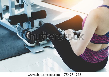 a strong young woman pulling the rope at a gym. Female working out with rope at the gym.