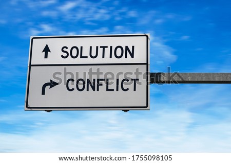 Solution versus conflict. White two street signs with arrow on metal pole. Directional road, Crossroads Road Sign, Two Arrow. Blue sky background. Royalty-Free Stock Photo #1755098105