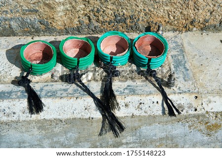green plastic tubes cut and tied with black rope