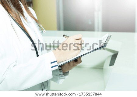Close up Medical doctor woman on white background holding stethoscope, taking notes in medical form. Doctor using clipboard in modern clinic. Perfect medical service in hospital.