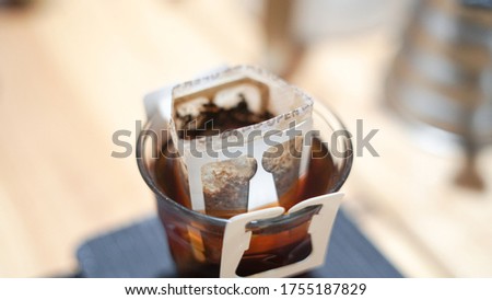 close up of instant filtered coffee, or pour-over is a method which involves pouring hot water over roasted, 
waiting for the coffee to dissolver on water, background.