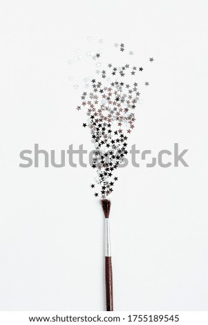 paint brush and sparkling silver stars on white background. magic concept. explosion of star sparkles. copy space.