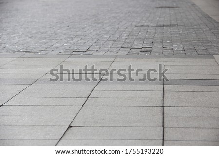 Grey tiles on the road. Square stone tiles. Backgrounds