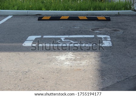 Parking space for a disabled person. White wheelchair sign in the Parking 