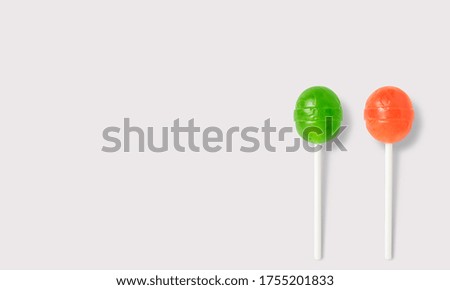 Orange and green lollipop on a white background