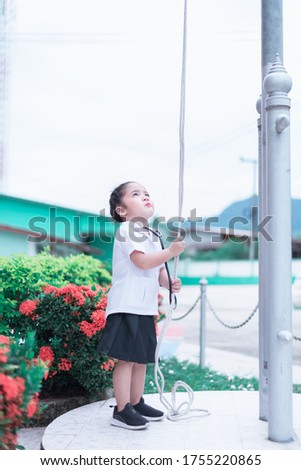 A Cute and lovely Asian baby girl in nurse uniform dress fly the flag