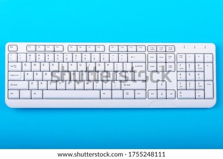 Keyboard isolated. White keyboard on blue background. Top view. Close up