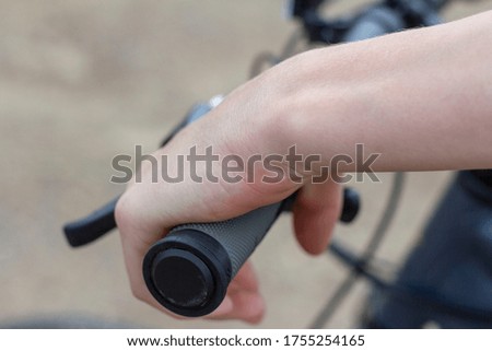 Close-up of a teenager's hands on the handlebars of a Bicycle.