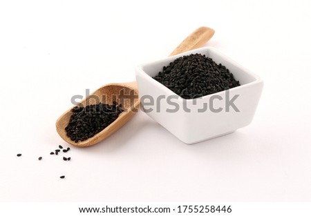 Black seed on a piece of burlap and wooden spoon isolated on white background Royalty-Free Stock Photo #1755258446
