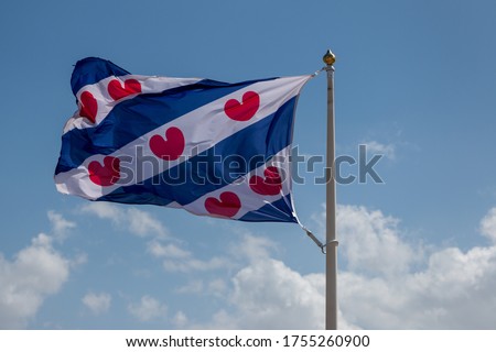 A Dutch flag that represents the province of Friesland, the red hearts symbolize lily leaves that are common in this province Royalty-Free Stock Photo #1755260900
