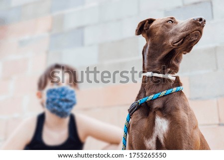 portrait of young girl with protective face mask with flower texture accompanied by her dog. New concept normality
