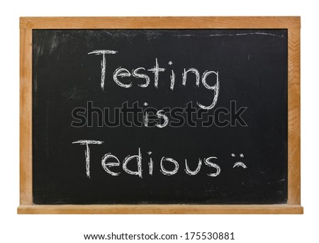 Testing is tedious hand written in white chalk on a black chalkboard isolated on white