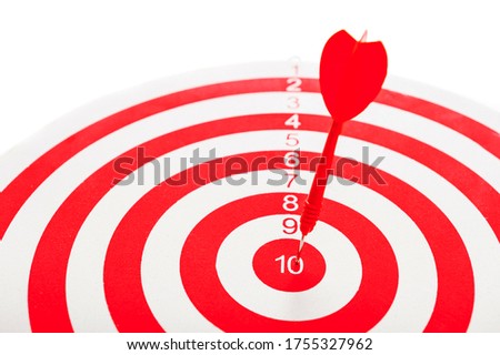Close-Up of a Bull's Eye On a Wall with a red dart on a white background.
