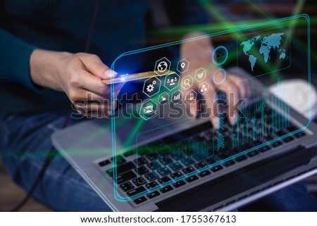 Digital marketing concept. Businesswoman holding a credit card with laptop on modern interface payments online shopping. blurred image.