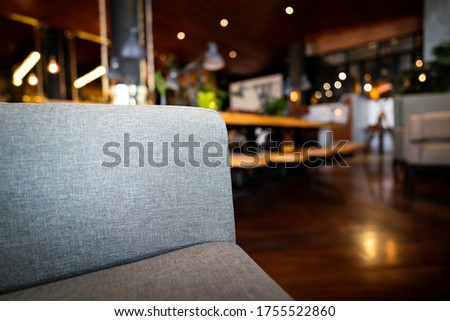 Close-up photo at sofa armchair with blurred background of vintage restaurant or hotel lobby. Selective focus on the fabric surface.
