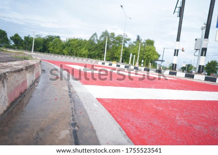 The white-red road surface is a sign to stop at the traffic light intersection in Thailand.